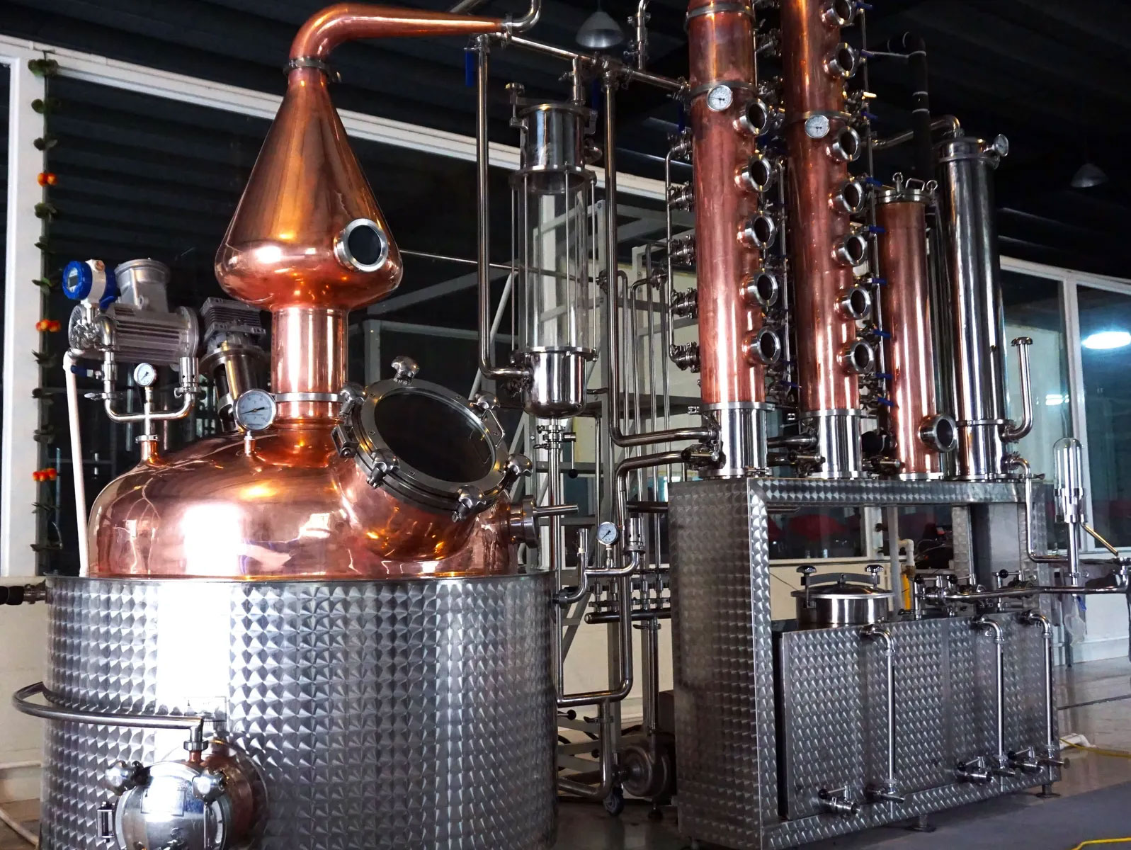 Copper pot still connected to rectifying columns and condensers