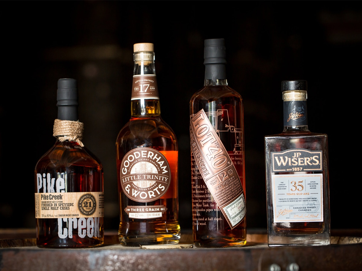 A lineup of Canadian whisky bottles on a bar